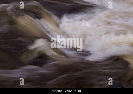 Abstrakte, langsame Aufnahme von schnell fließendem weißem Wasser. Stockfoto