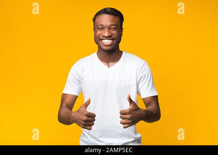 Afro Man Hat Thumbs-Up Über Yellow Studio Hintergrund Gestybt Stockfoto