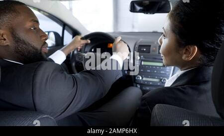 Attraktive Frau überredet ihren Kollegen, Machination zu begehen und im Auto zu sitzen Stockfoto