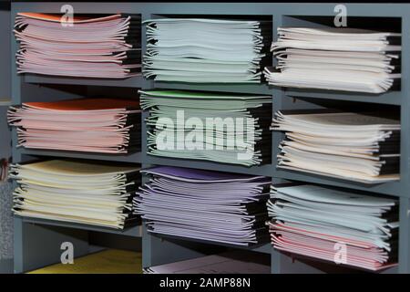 Büroregale, die mit mehrfarbigen Ordnern und Dokumenten gestapelt sind. Stockfoto