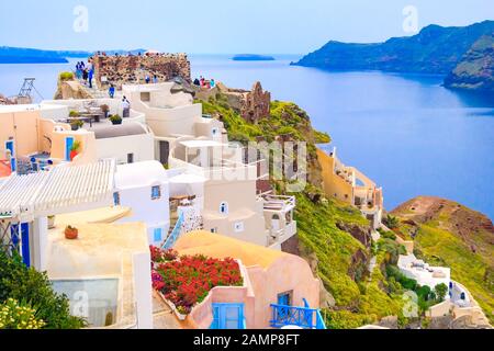 Santorini, Griechenland - 26. April 2019: Stadtpanorama von Oia mit bunten Häusern, Schloss und blauem Meer Stockfoto