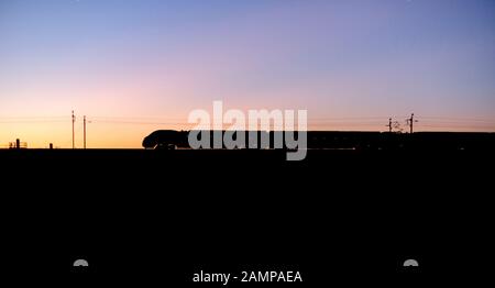 Virgin Trains/Avanti Westküste Alstom Pendolino train eine Silhouette bei Sonnenuntergang auf dem West Coast Mainline. Stockfoto