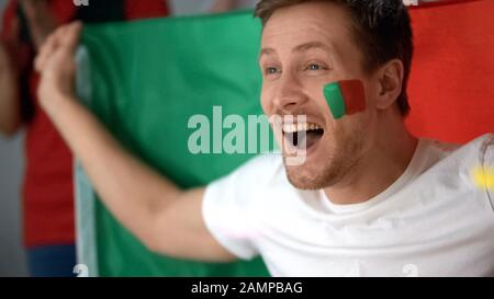 Aufgeregte Anhänger Portugals feierten das Ziel und beobachteten das Fußballspiel im fernsehen Stockfoto