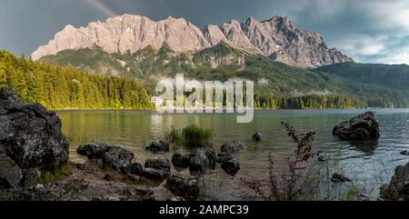 Felsen am Ufer, Eibsee vor Zugspitzmassiv mit Zugspitze mit Regenbogen, Wetterstein Range, bei Grainau, Oberbayern, Bayern Stockfoto