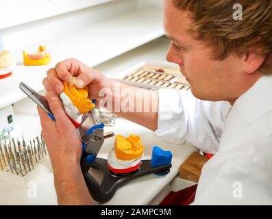 Zahntechniker, Zahntechnik, Modellierung an Unterkieferpartialhärenten mit Wachs, Deutschland Stockfoto