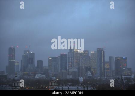 Ein nebeliger Blick auf Canary Wharf vom Royal Observatory in Greenwich, London, da die Wetterwarnungen im ganzen Land weiterhin in Kraft bleiben, nachdem Storm Brendan Winde von fast 90 mph in Teile des Vereinigten Königreichs brachte. Stockfoto