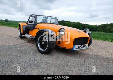 Ein oranger Caterham-Sportwagen auf der alten Landebahn Stockfoto