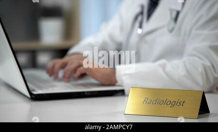 Der Radiologe füllt die medizinische Dokumentation in der Klinik aus und füllt den Bericht aus Stockfoto