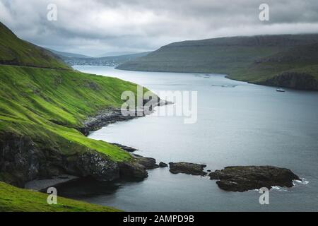 Dramatischen Blick auf grünen Hügeln von Vagar Insel und Sorvagur Stadt auf Hintergrund. Färöer, Dänemark. Landschaftsfotografie Stockfoto