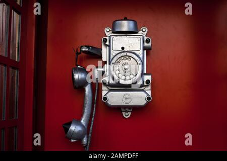 Telefon-Box für die Straße. Alte schmutzige und verkratzte Telefonzelle in roter Kabine Stockfoto