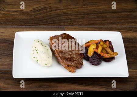 Irisches Sirloin-Rindersteak serviert mit cremigen Kartoffelpüreen und geröstetem Gemüse. Stockfoto