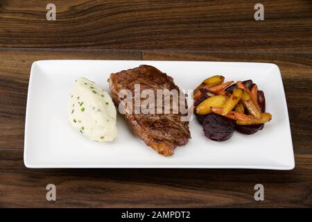 Irisches Sirloin-Rindersteak serviert mit cremigen Kartoffelpüreen und geröstetem Gemüse. Stockfoto