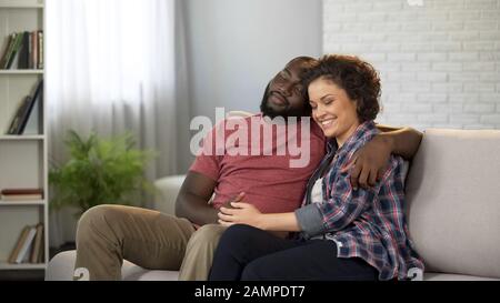 Ein Paar sitzt gern in ihrer Wohnung, träumt von Zukunft, glücklich zusammen Stockfoto