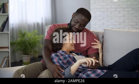 Ein Paar in Liebe kuscheln auf dem Sofa, genießen Zärtlichkeit und Liebe zusammen, die Ehe Stockfoto
