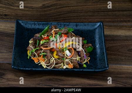 Asiatisches Rühren gebratenes Rindfleisch mit Nudeln und Gemüse. Stockfoto