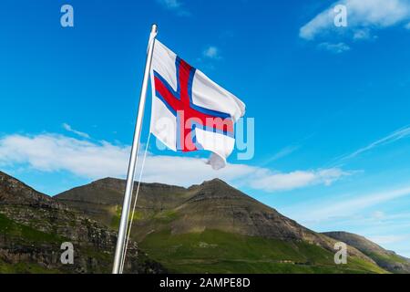 Flagge der Färöer winken gegen einen bewölkten Himmel Stockfoto