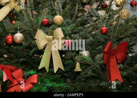 Weihnachtshintergrund: Nahaufnahme eines dekorierten Weihnachtsbaums mit Bändern und Baubeln. Stockfoto
