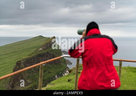 Nebel Blick auf den alten Leuchtturm aus Sicht mit touristischen Fernglas auf der Insel Mykines, Färöer, Dänemark. Landschaftsfotografie Stockfoto