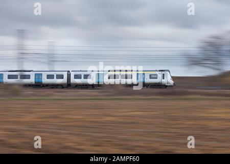 Govia Thameslink (GTR) Klasse 700 bei souldrop auf dem Midland mainline mit einem Bedford Brighton Zug Stockfoto