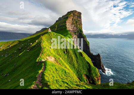 Kallur Leuchtturm auf grünen Hügeln der Insel Kalsoy, Färöer, Dänemark. Landschaftsfotografie Stockfoto