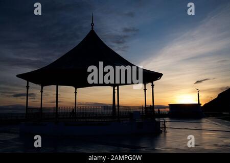 Silhouette eines Pavillons am Wasser in Bray, County Wicklow, Irland bei Sonnenuntergang. Stockfoto