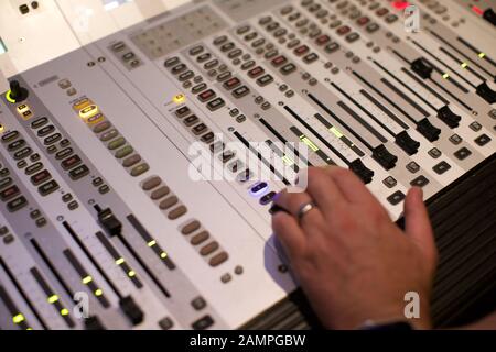 Nahaufnahme der Hand ein Techniker ein Fader bewegt wird. Schalten Sie einen Broadcast Mischpult Stockfoto