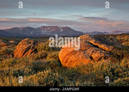 WY03961-00...WYOMING - Die untergehende Sonne, die warmes Licht über offenen Präriegebieten wirft, und der Wind River Reichen vom Hochland über dem Big Sandy Stockfoto