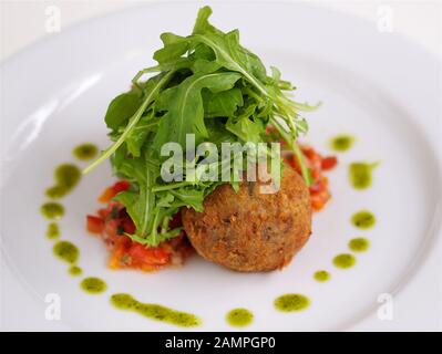 Frittierte Ziegen Käse serviert mit Rucola Blätter und Tomaten Salsa. Stockfoto