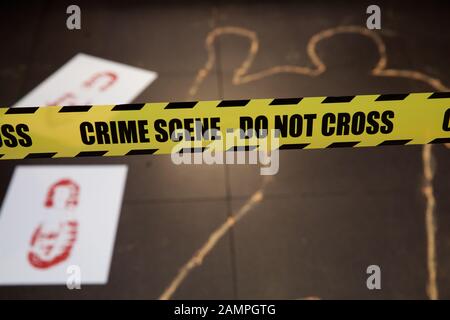 Mock Crime Scene mit gelben Polizei cordon Ribbon und Kreide Körperumriss. Stockfoto