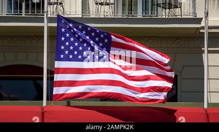 Amerikanische Flagge flattert auf dem Pfosten vor dem Bau, Patriotismus, Demokratie Stockfoto
