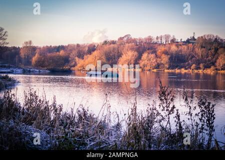 Linlithgow Lake mit Booten und Frost auf dem Gras, Linlithgow, Schottland, Großbritannien Stockfoto