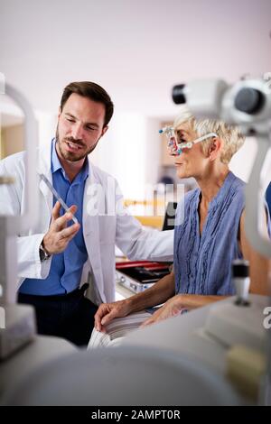 Optiker Prüfung der älteren Frau in der modernen Augenheilkunde Klinik Stockfoto