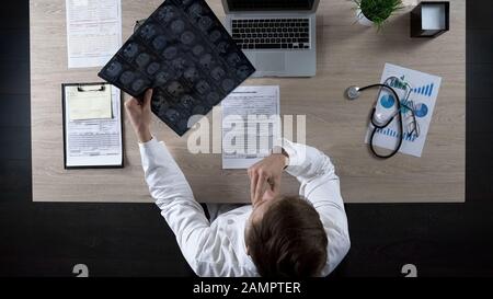 Erfahrener Neurologe untersucht Gehirn-MRT des Patienten zur Diagnose einer Krankheit, topview Stockfoto