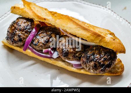 Türkischer Kofte Ekmek/Meatball Sandwich mit roten Zwiebeln. Traditionelle fast Food aus der Türkei. Bereit zum Essen. Stockfoto