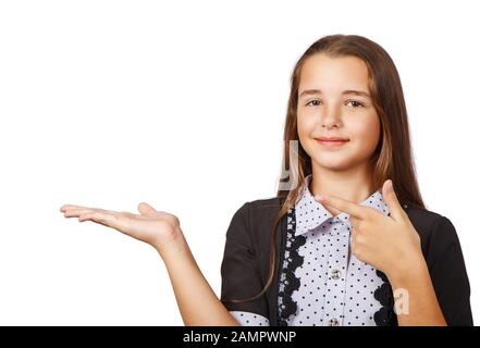 Überraschte Teenager-Mädchen, die ein Produkt zeigen. Schöne brünette Teenager-Mädchen mit langen Haaren, die auf die Seite zeigen. Ihr Produkt präsentieren. Isoliert auf weißem B. Stockfoto