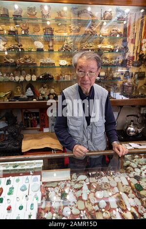 Hong Kong Shop Interior; ein ladenbesitzer hinter der Theke im Jade shop, Kowloon Hong Kong Asien Stockfoto