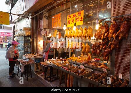 Hong Kong Metzgerei; eine Frau kaufen Fleisch von einem Metzger Shop im Geflügel spezialisiert ist; Kowloon, Hong Kong Asien Stockfoto