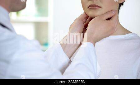 Männlicher Arzt prüft Hals und Hals des Patienten, Gesundheitsuntersuchung im Krankenhaus Stockfoto