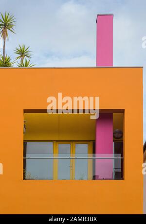 Moderne Architektur mit hellorangefarbenem Gebäude mit gelben und rosafarbenen Abschnitten. Fashion and Textile Museum, gegründet von Zandra Rhodes, South London, Großbritannien. Stockfoto