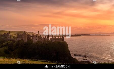 Mittelalterliche Dunluce Castle auf der Klippe in Bushmills, Nordirland bei Sonnenuntergang ruiniert. Drehort der beliebten TV-Serie, Spiel der Throne Stockfoto