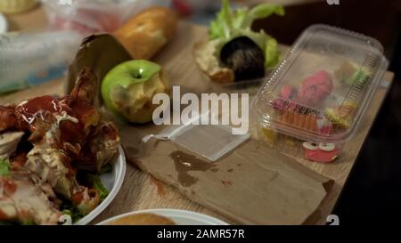 Ekelhafte schmutzige Teller voller ungesunder Essensreste nach der Studentenparty Stockfoto