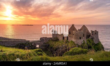 Mittelalterliche Dunluce Castle auf der Klippe in Bushmills, Nordirland bei Sonnenuntergang ruiniert. Drehort der beliebten TV-Serie, Spiel der Throne Stockfoto