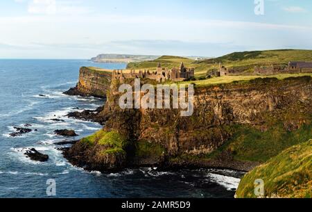 Mittelalterliche Dunluce Castle auf der Klippe in Bushmills, Nordirland bei Sonnenuntergang ruiniert. Drehort der beliebten TV-Serie, Spiel der Throne Stockfoto