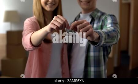 Glückliches Paar lächelnd mit Schlüsseln aus der neuen Wohnung, erschwingliche Bankkredite Stockfoto