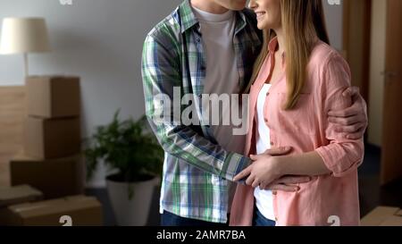 Liebevoller Mann umarmt und küsst Verlobte, genießt gemeinsam neues Leben, Glück Stockfoto