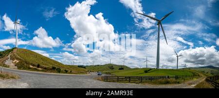 Panoramablick auf die ländliche Bauernhofweide von Hügeln und Tälern mit Windkraftanlagen auf den Gipfeln Stockfoto