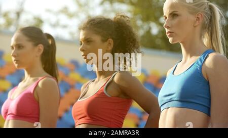 Selbstbewusste Sportlerinnen und Sportlerinnen, die starke Konkurrenten in einander sehen Stockfoto