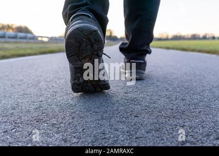 Die Nahaufnahme von Wanderschuhen auf der Straße, ausgewählte Fokussierung auf den linken Schuh Stockfoto