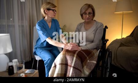Pflegefachkraft hält die Hand der Patientin und versucht, die medizinische Betreuung und Pflege zu unterstützen Stockfoto