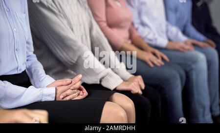 Eine Gruppe von Leuten, die in der Reihe sitzen, auf einen Arzt warten und die Kunden nicht respektieren Stockfoto